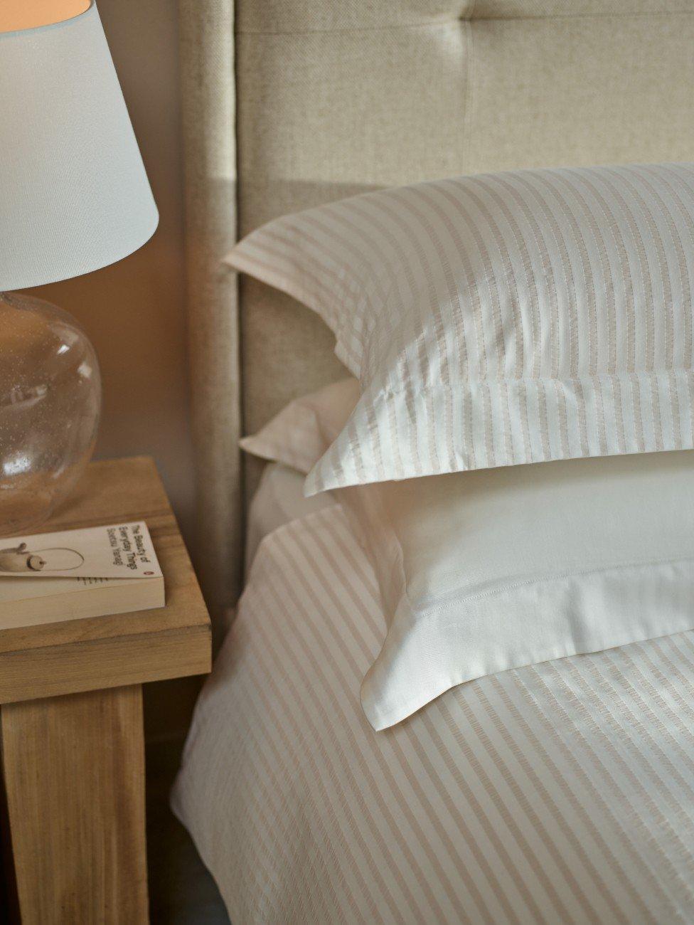 a bed with a nightstand and lamp on a nightstand