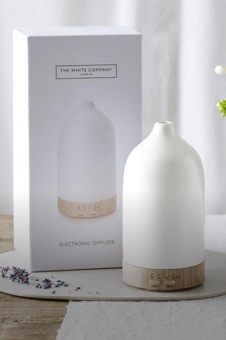 a white and blue aroma diffuser sits on a table next to a box