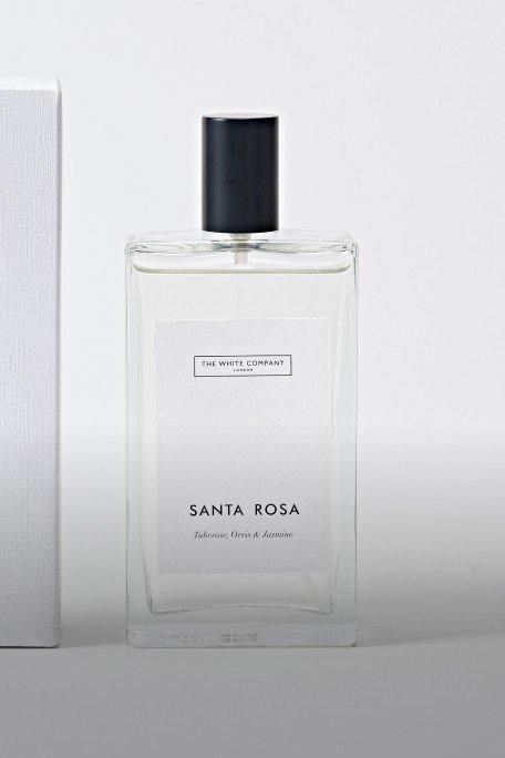 a white bottle of perfume next to a white box