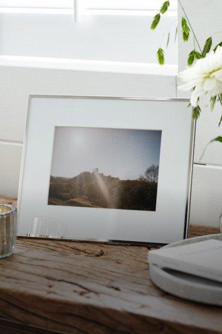 a picture of a picture frame sitting on a table next to a vase of flowers