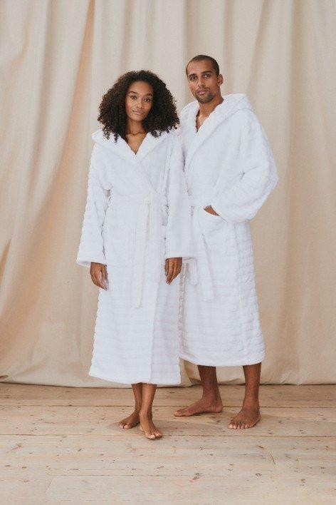 a man and woman in white bathrobes standing next to each other