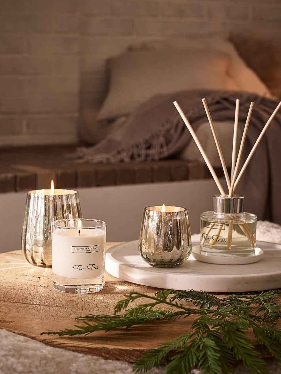 a table with candles, a vase and a plant on it