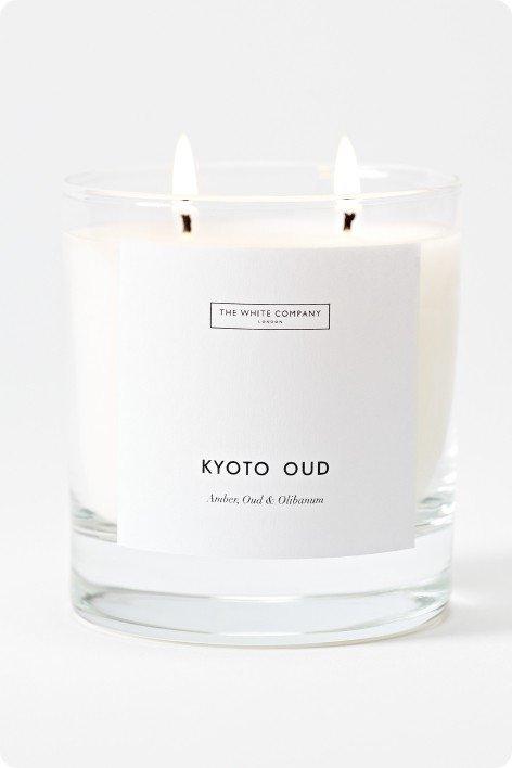 a white candle with a label that says kyoto oud