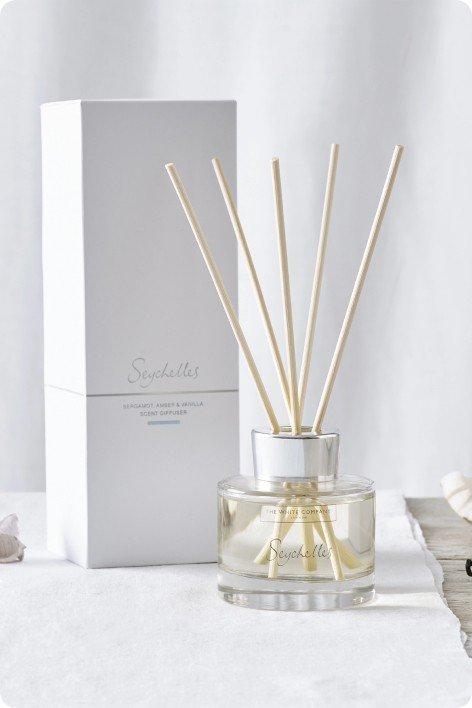 a reed diffuser with sticks and a box next to it