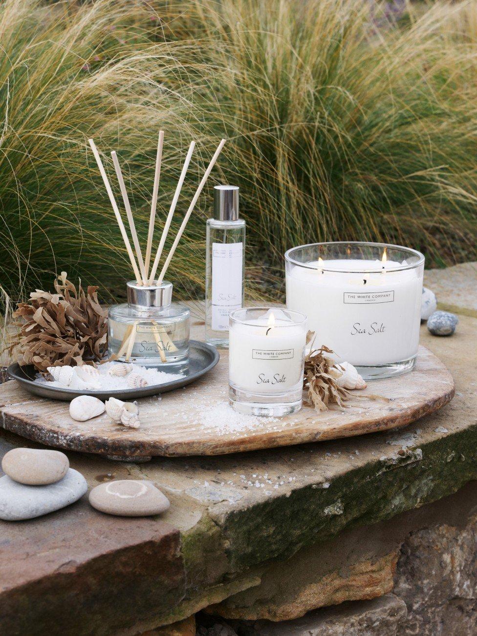 a stone slab with candles, rocks and sticks on it