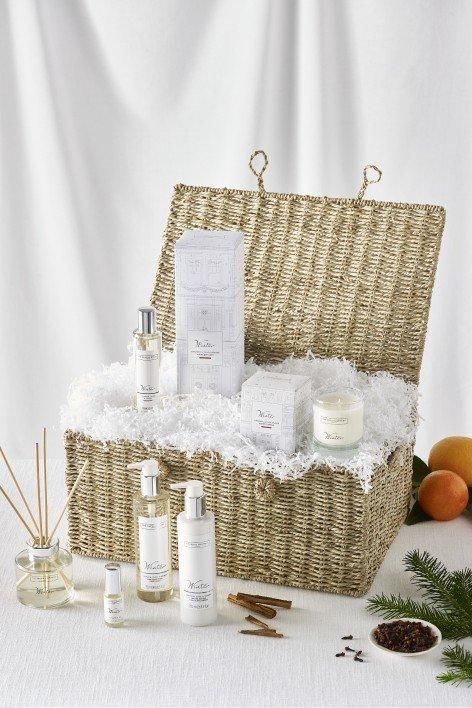 a wicker basket with candles, a candle holder, and other items