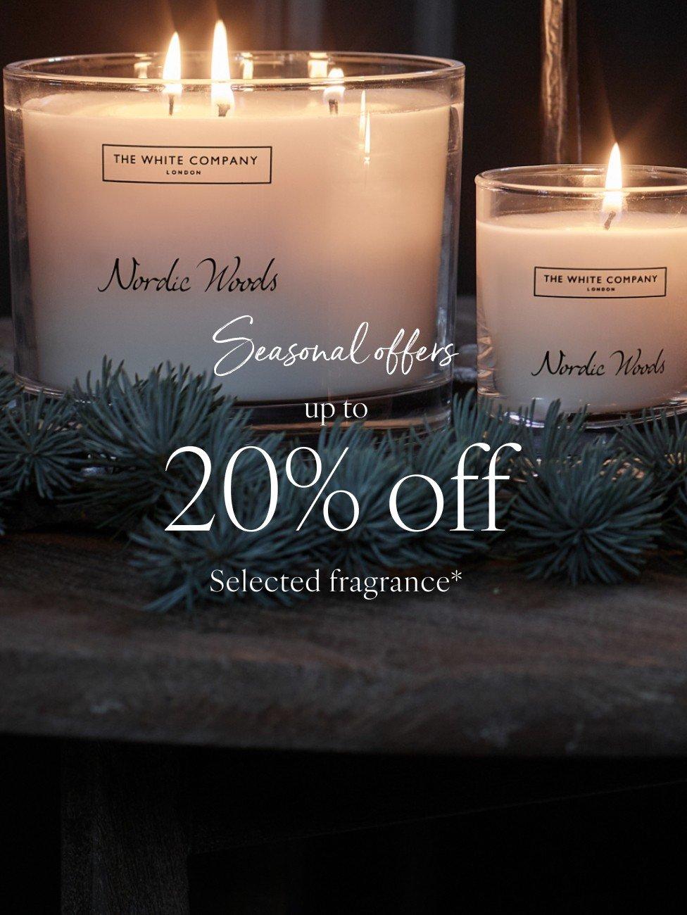 two candles are lit on a table with the words 20 % off selected fragrance