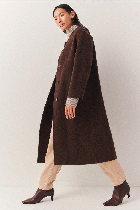 a woman in a brown coat and brown boots