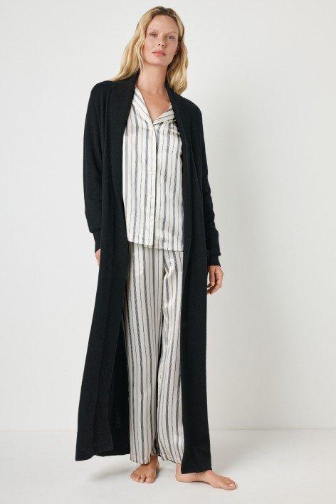 the model is wearing a long black robe and striped pajamas