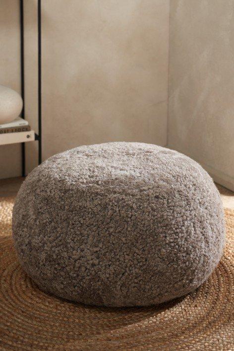 a rug with a small ottoman on it in a room