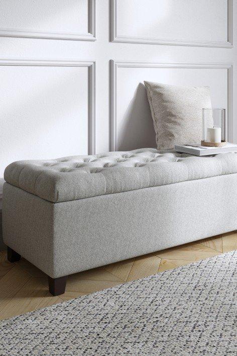 a white bench with a pillow on top of it in a room