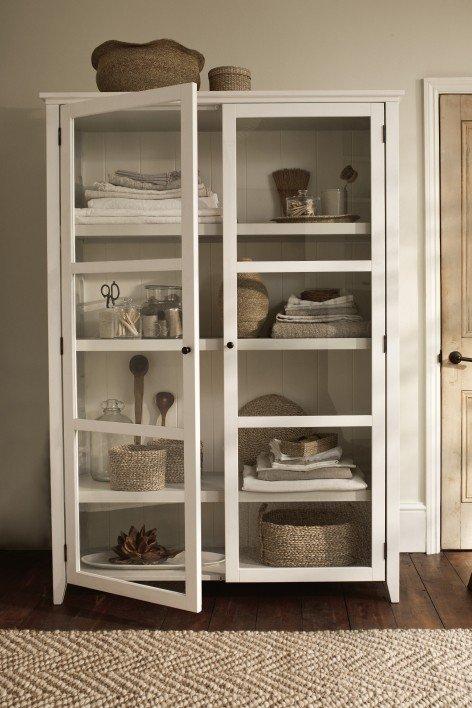 a white cabinet with a vase and a vase of flowers