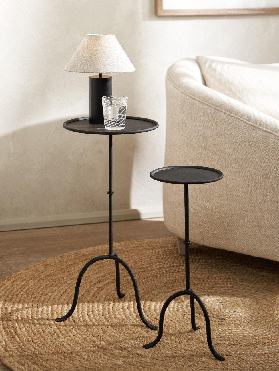 a small table with a lamp on it next to a rug