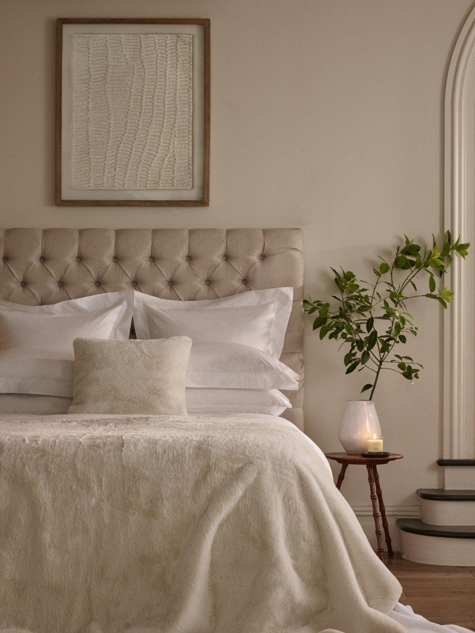 a bed with a white headboard and footboard with a nightstand