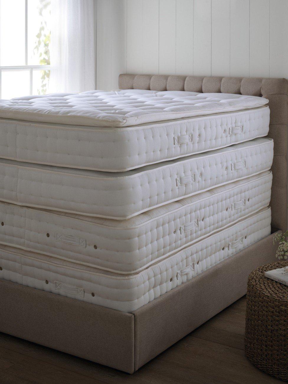 a stack of four mattresses on top of each other in a room