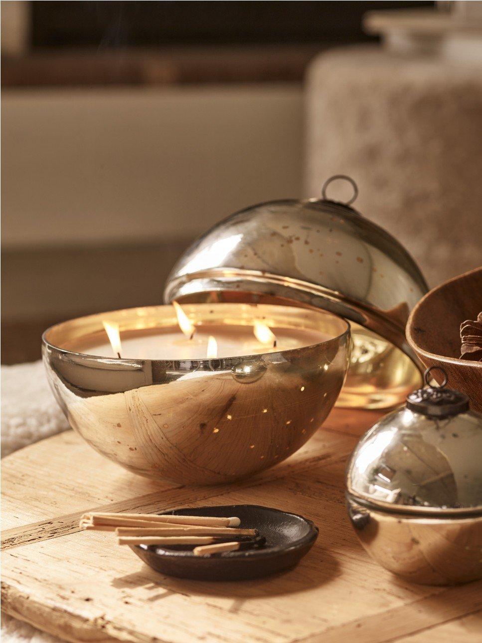 a wooden table with a bowl of candles and a candle holder