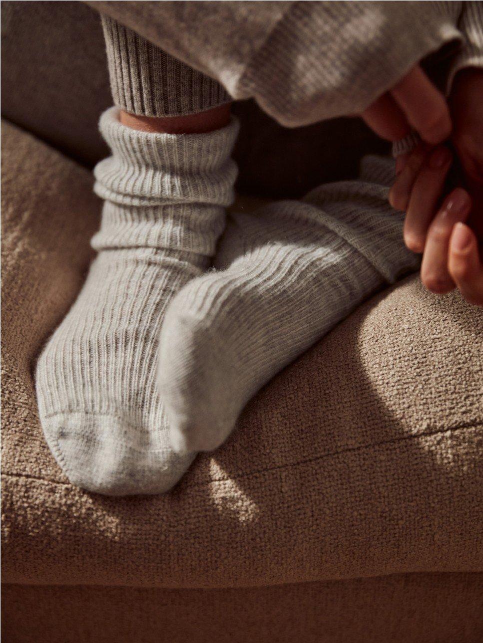 a person wearing a pair of white socks on a couch