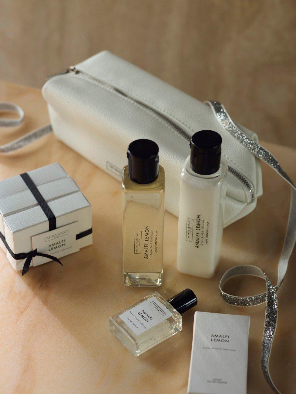 a white bag with a white purse and a white bottle of perfume