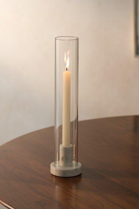 a candle is sitting in a glass vase on a wooden table