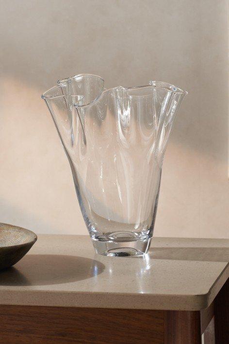 a glass vase sitting on a table next to a plate