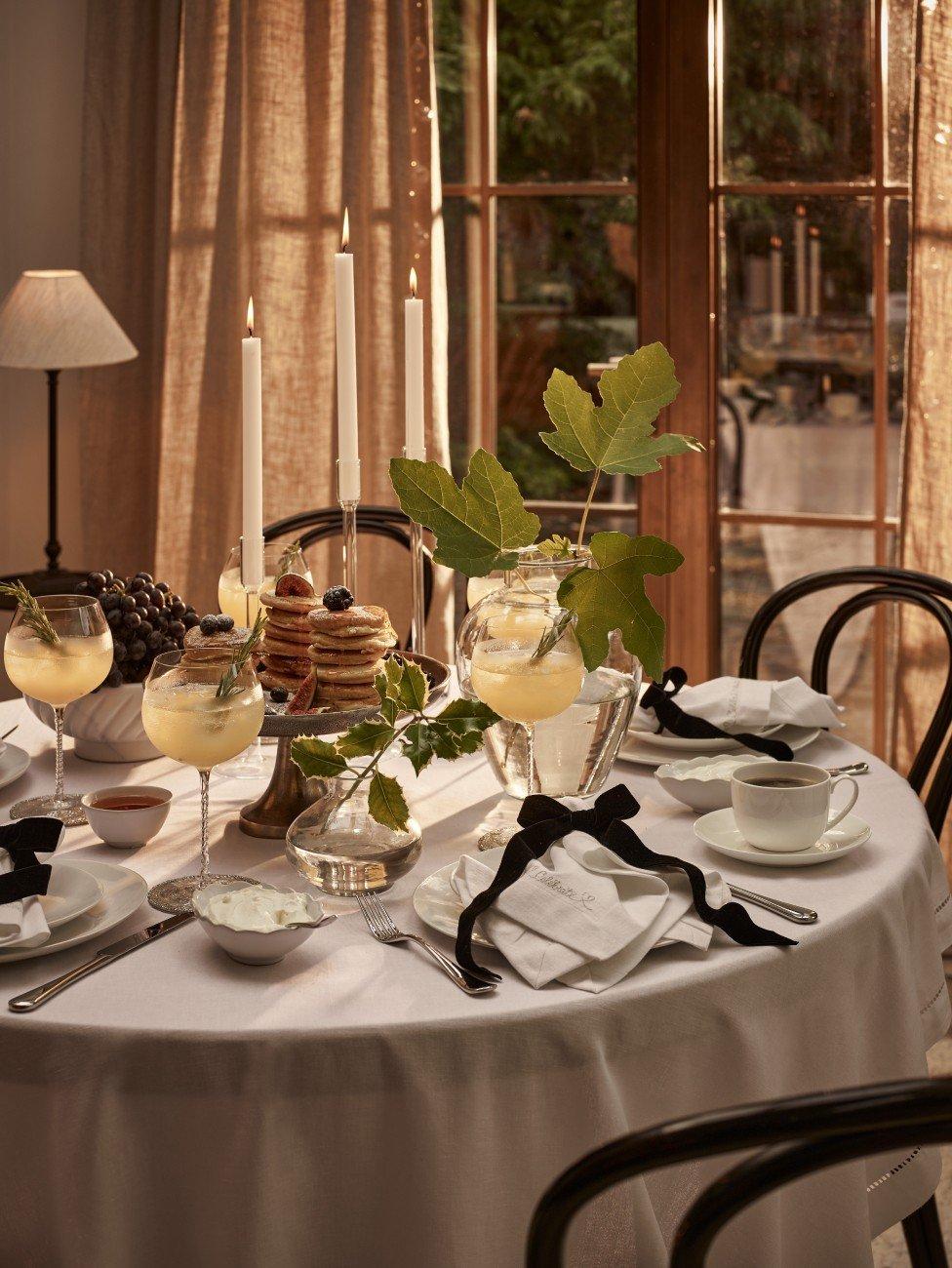 a table set for a dinner party with candles and wine glasses