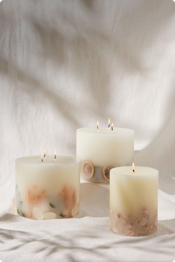 three candles are sitting on a white surface with a white background