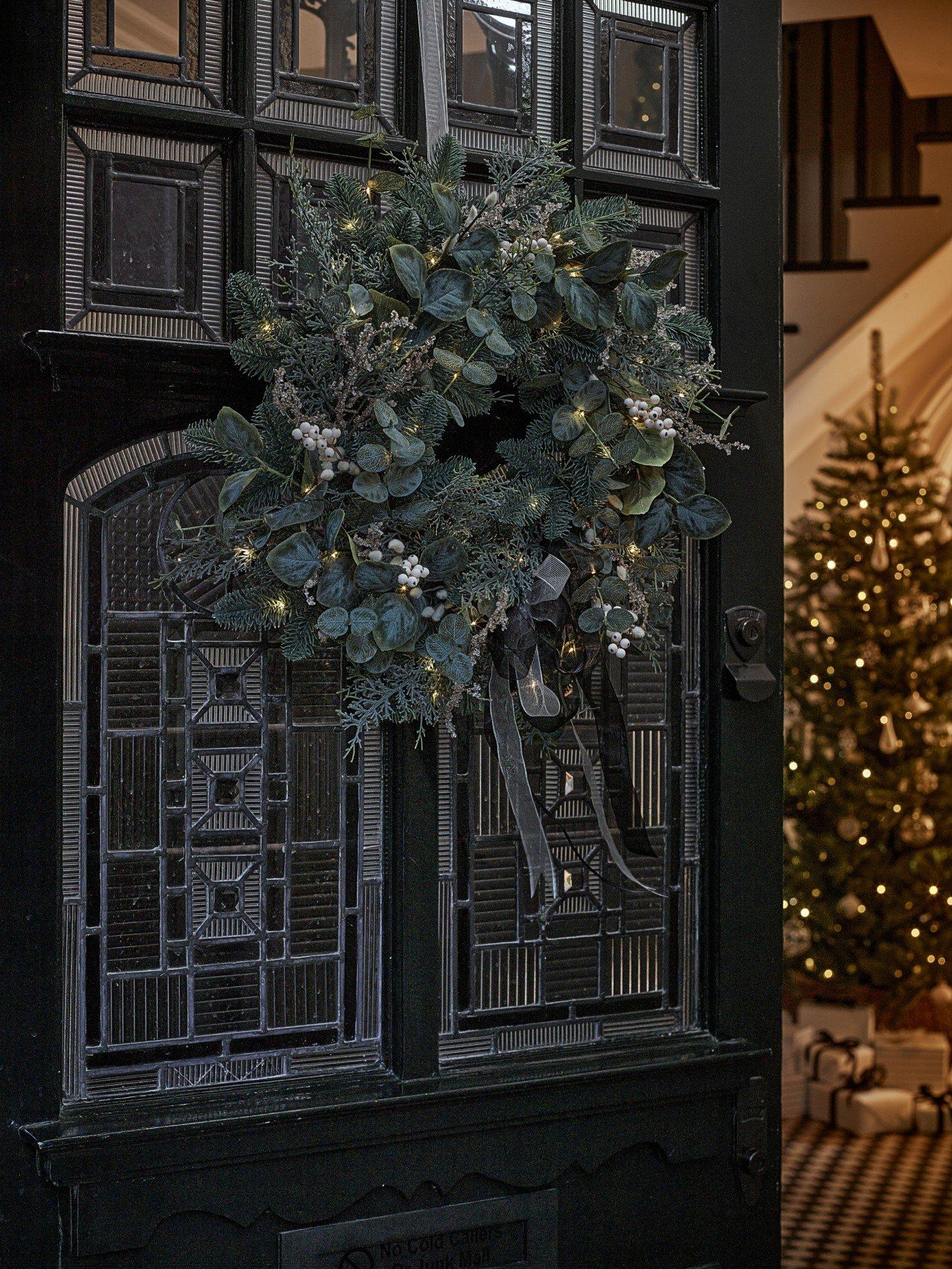 a wreath is hanging on the front door of a house