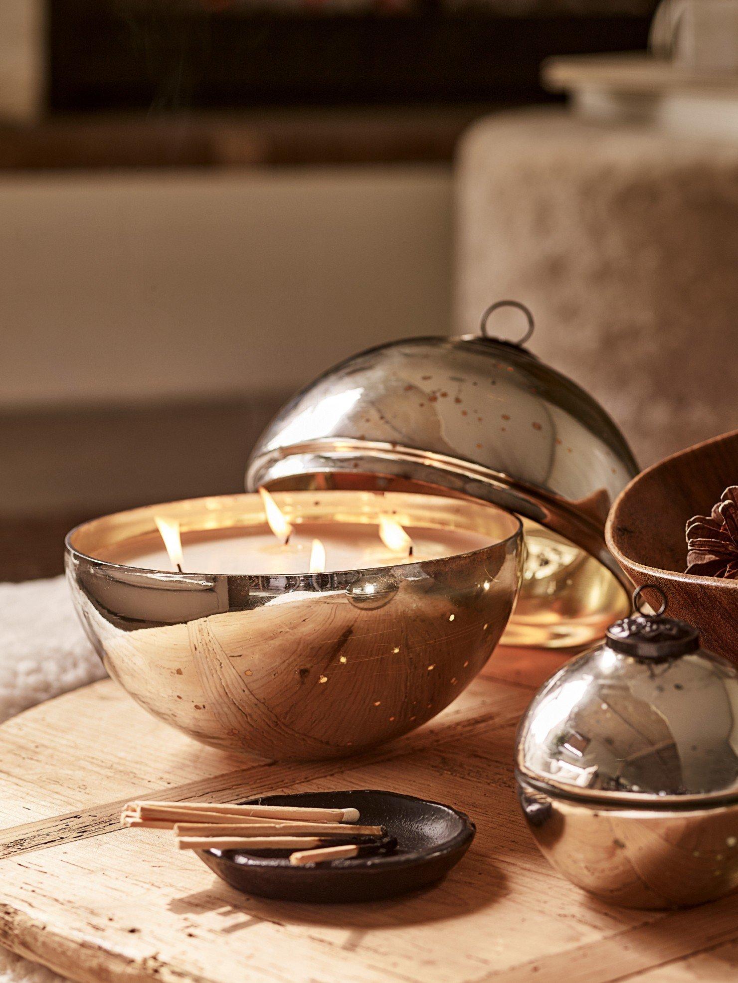 a wooden table with a candle and a bowl of nuts