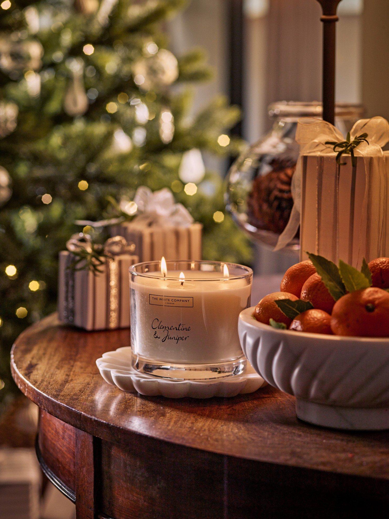 a table with a candle and some oranges on it