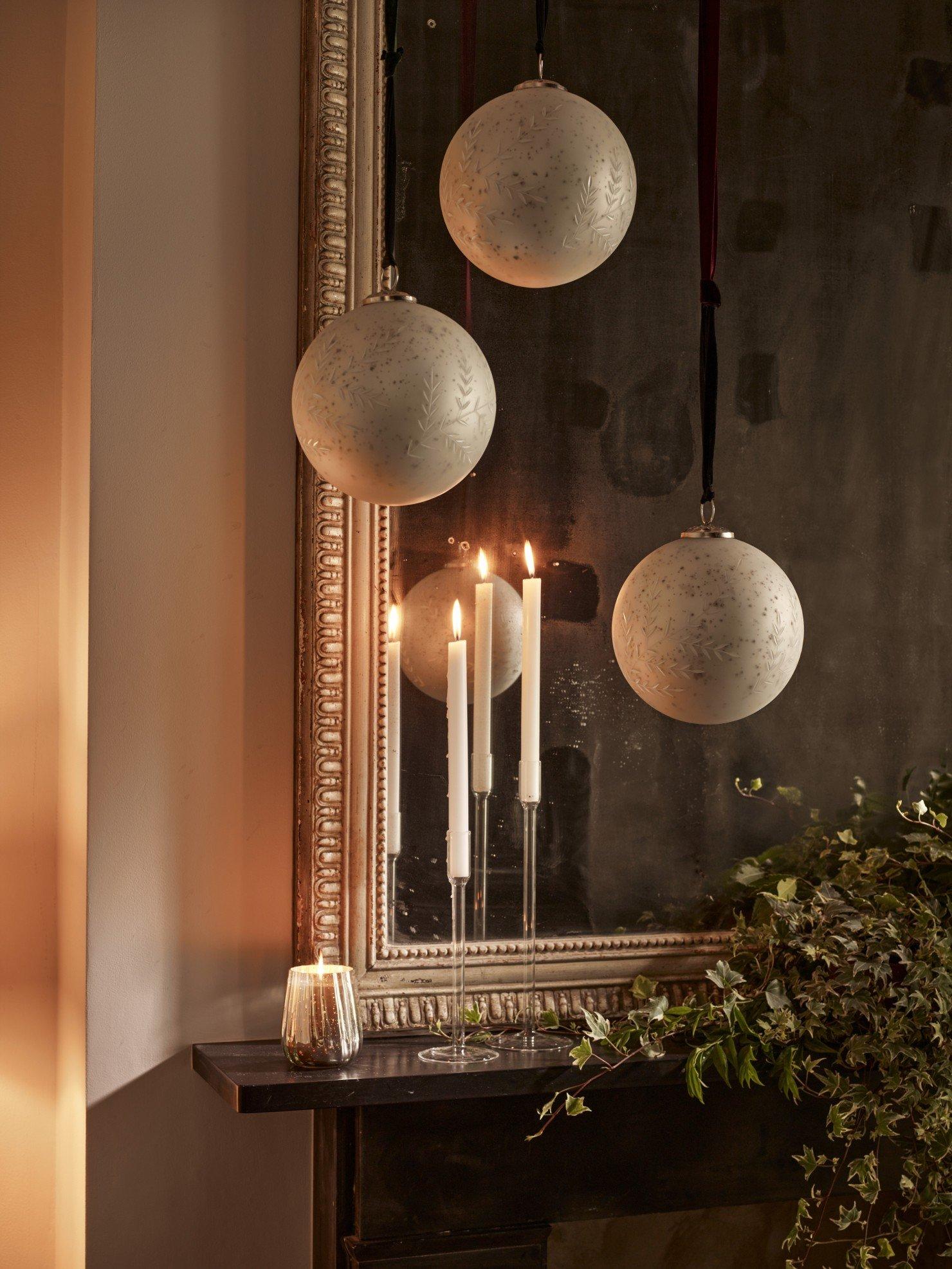 a mirror with candles and ornaments on it and a fireplace