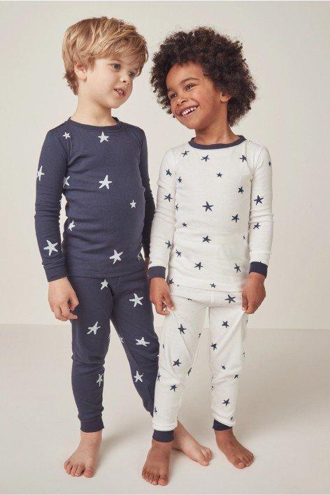 two children in pajamas standing next to each other