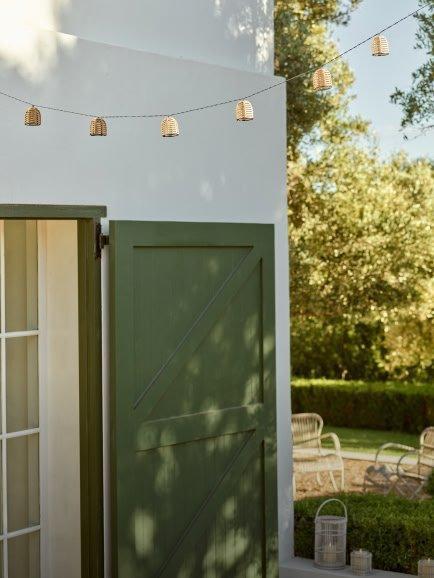 a green door with a light on it and a string of lights