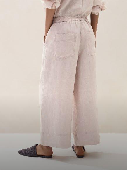 a woman in a white shirt and pants standing up