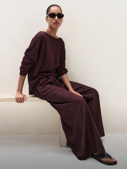 a woman in a long purple dress sitting on a bench