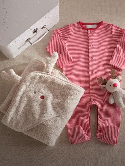 a baby's outfit and accessories are laid out on a bed