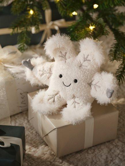 a small white stuffed snowflake sitting on top of a gift box