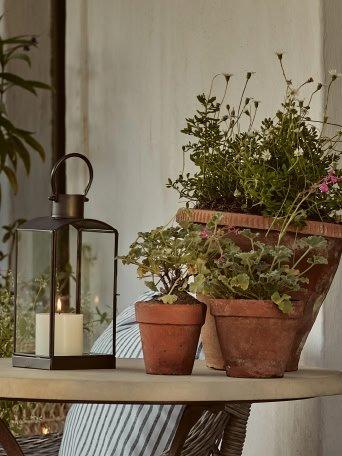 a table with a candle and potted plants on it