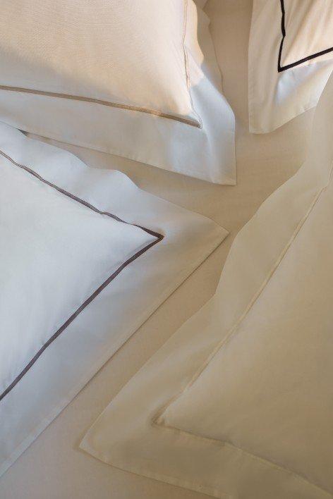 a close up of a bed with pillows and a sheet