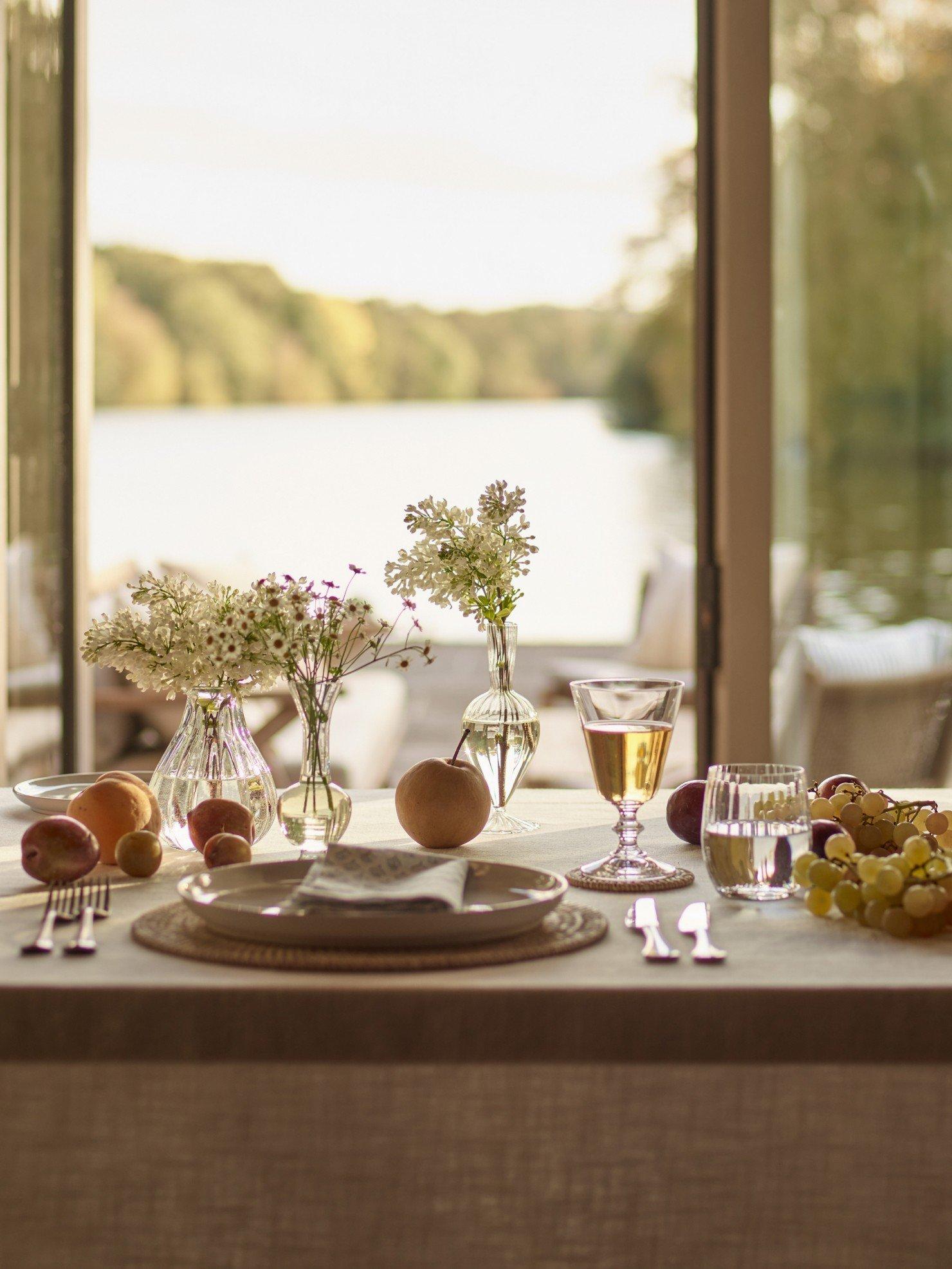 a table set with plates, glasses, and fruit on a table