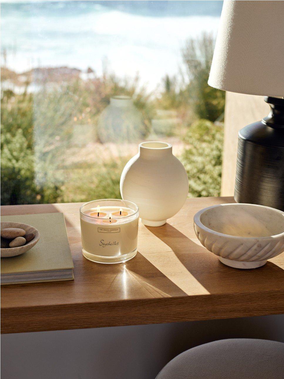 a candle and a marble bowl on a table