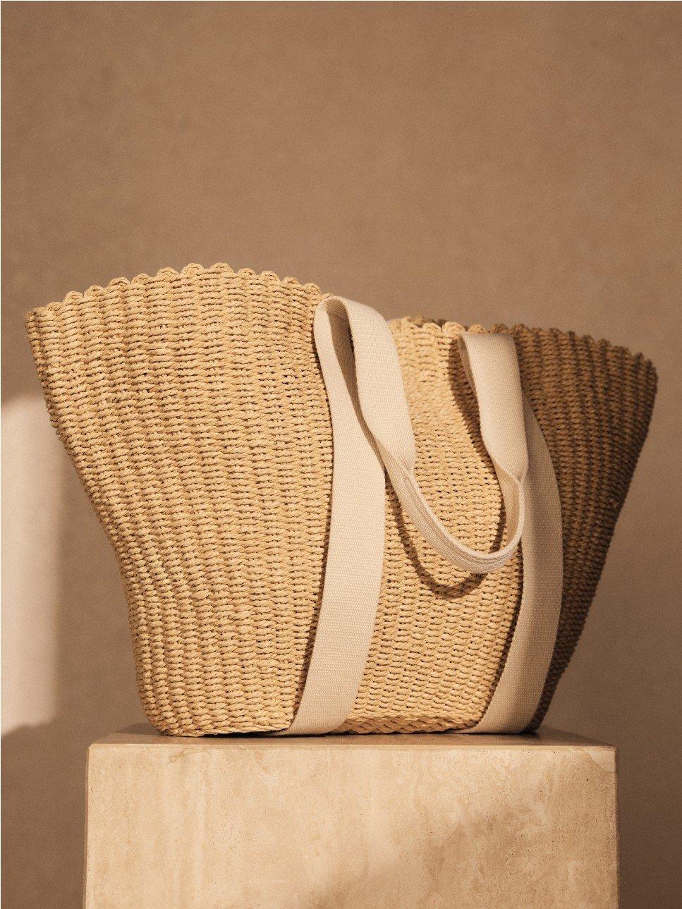 a straw beach bag on a pedestal 