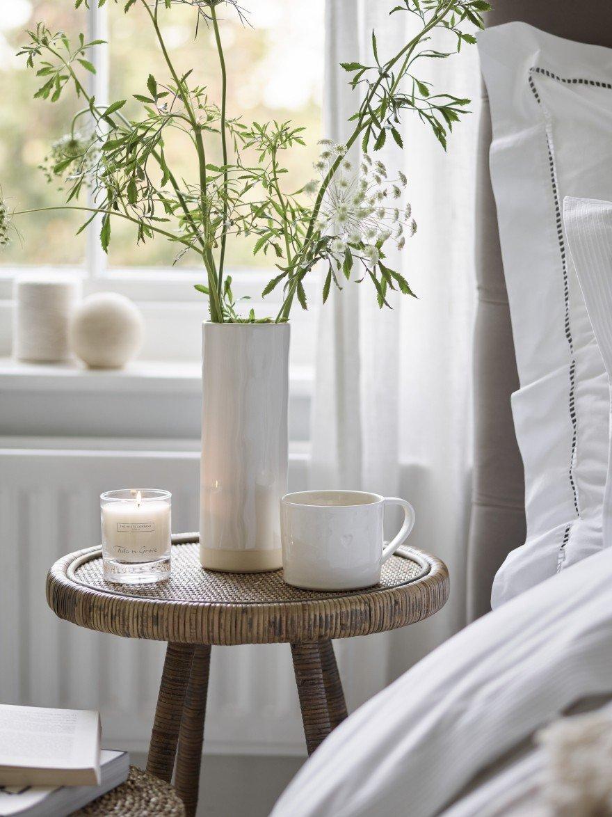 a mug and a candle and a vase with flowers 