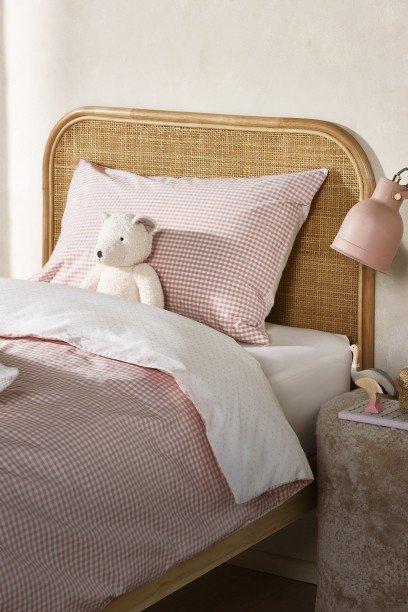 a white bed with a white comforter and a giraffe lamp
