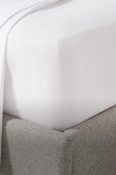 a bed with a white sheet and a white pillow on top