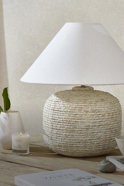 a table with a lamp and a book on it with a candle