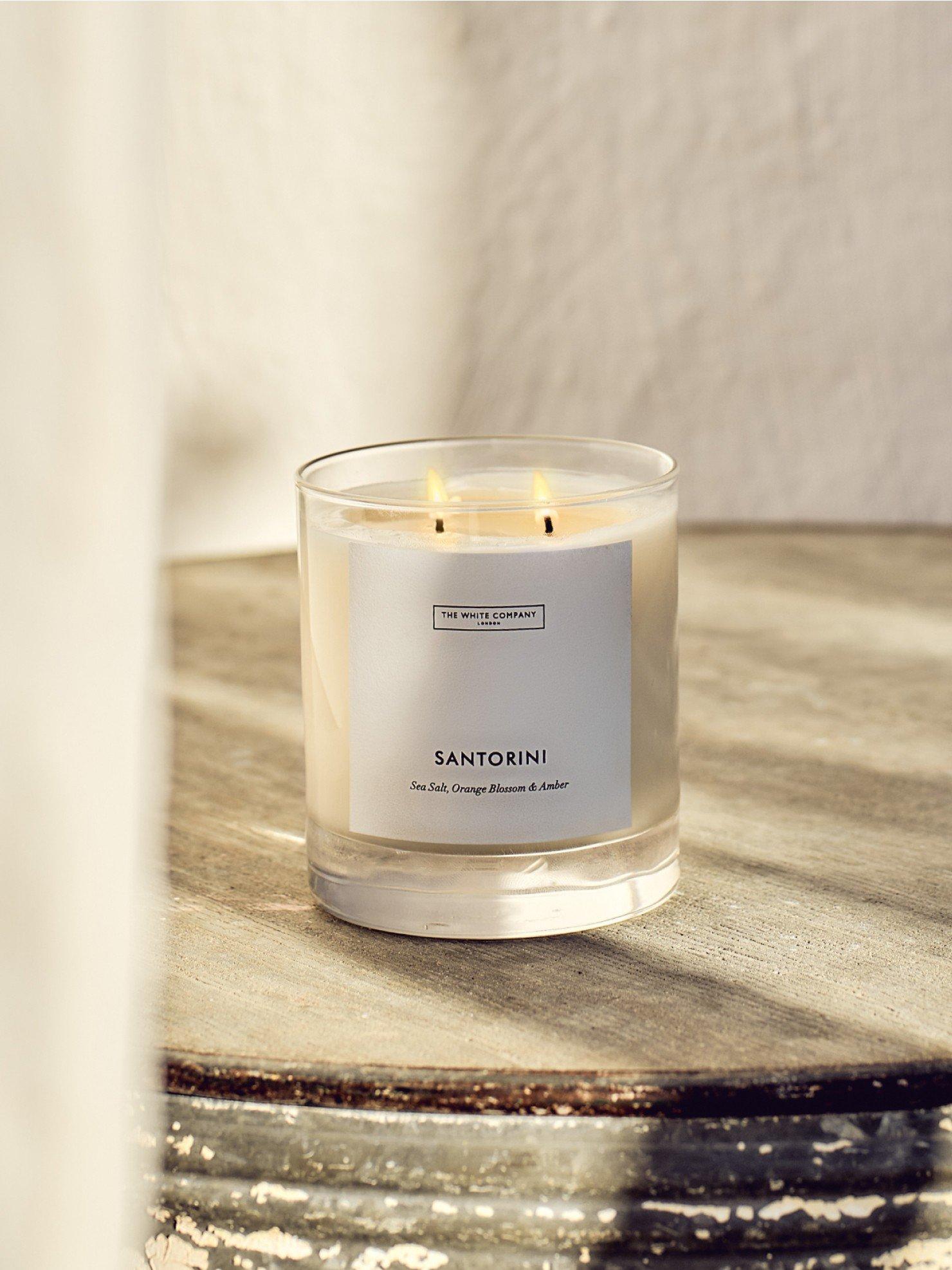 a candle sitting on a table with a glass next to it