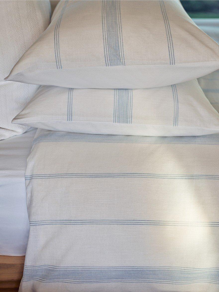 a close up of a bed with white sheets and pillows