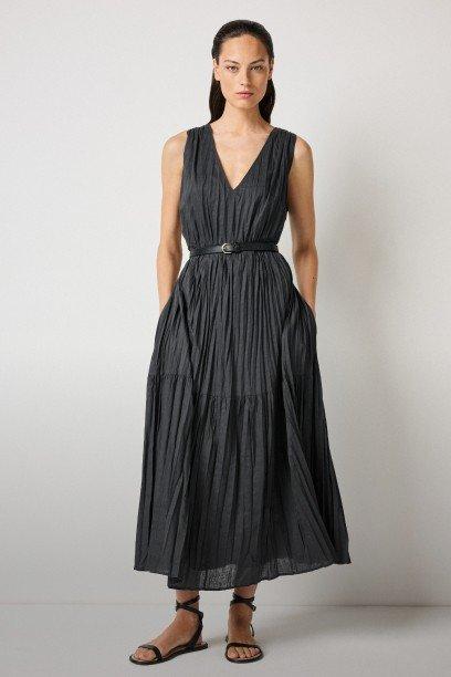 a woman in a black dress is standing