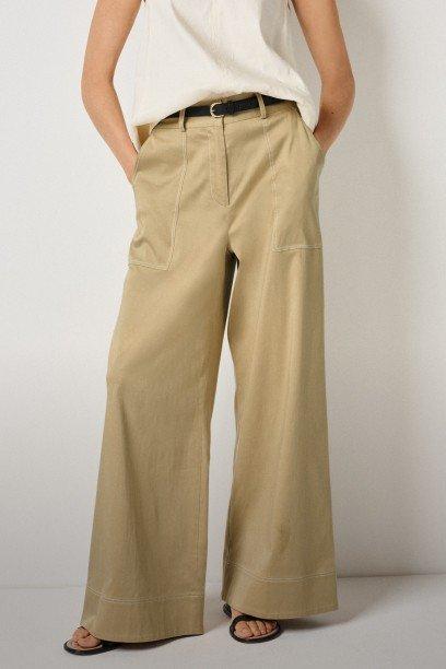 a woman in a white shirt and tan pants