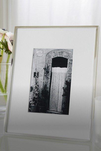 a picture of a picture frame sitting on a table next to a vase of flowers